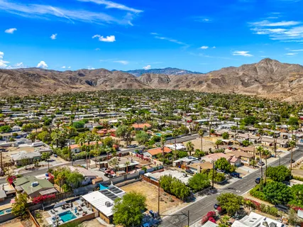 an aerial view of residential houses with outdoor space and trees
