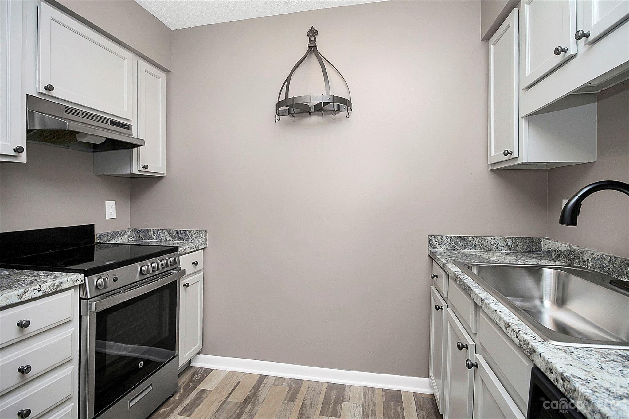 6144 Heath Ridge Court, Unit C Charlotte, NC 28210 - Photo 19 of 36 a kitchen with granite countertop a sink stainless steel appliances and cabinets