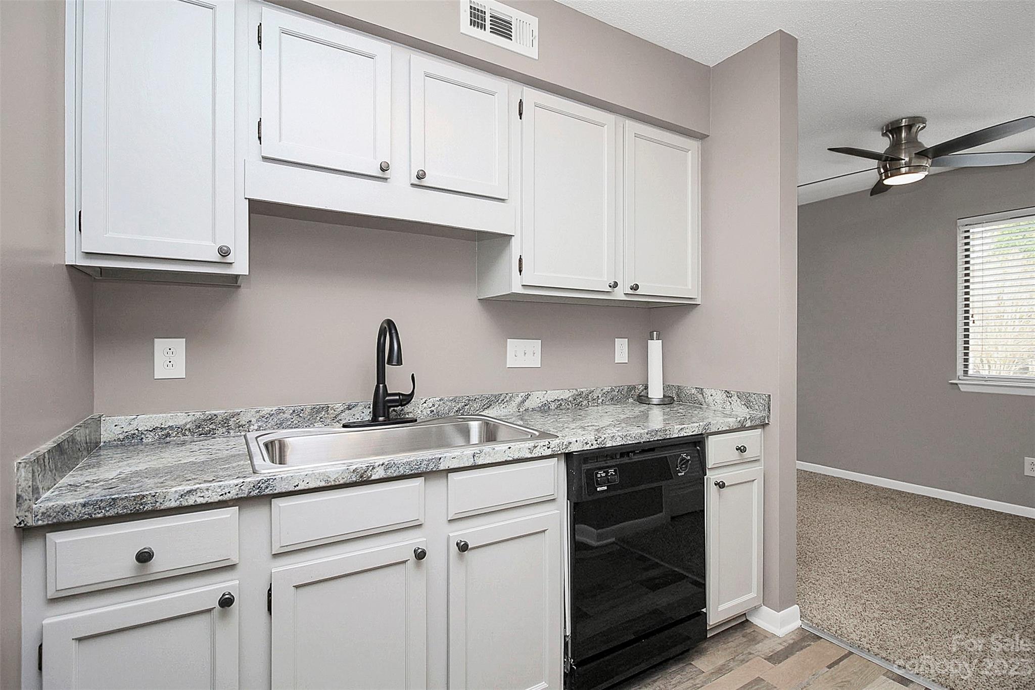 6144 Heath Ridge Court, Unit C Charlotte, NC 28210 - Photo 20 of 36 a kitchen with granite countertop white cabinets and a sink