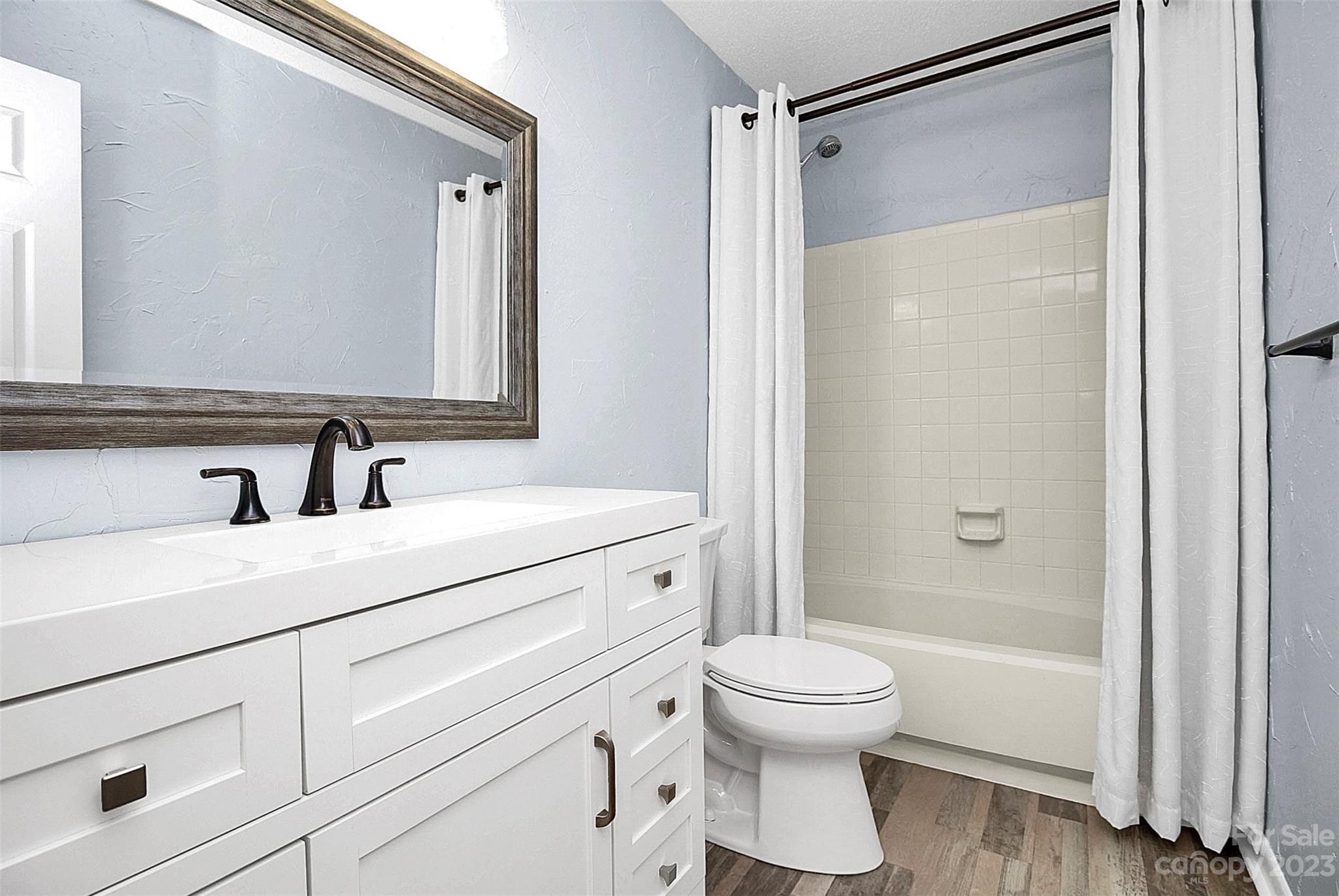 6144 Heath Ridge Court, Unit C Charlotte, NC 28210 - Photo 23 of 36 a bathroom with a shower sink vanity mirror and toilet