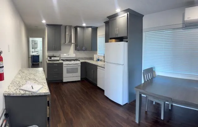 a kitchen with stainless steel appliances granite countertop a refrigerator a stove and a wooden floors