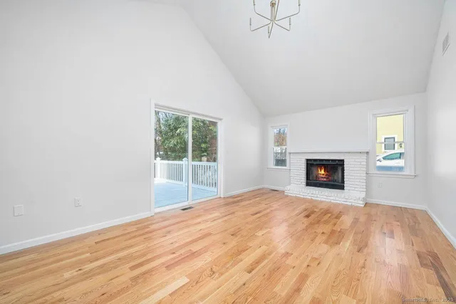 a view of empty room with wooden floor and fireplace
