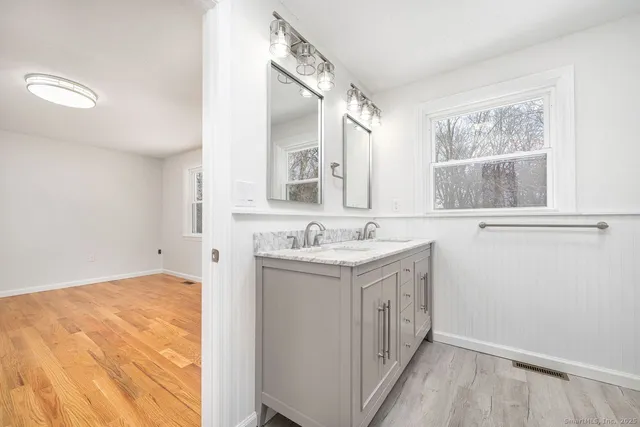 a bathroom with a granite countertop sink and a mirror