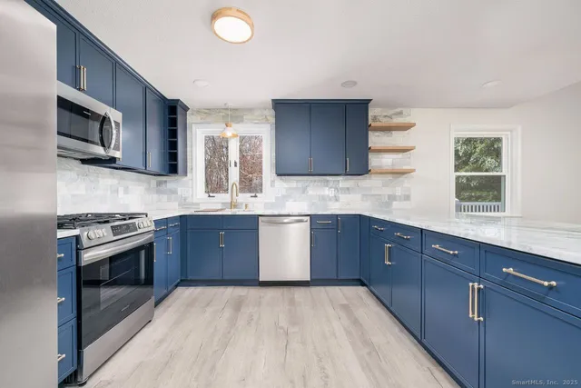 a kitchen with stainless steel appliances granite countertop a sink stove and microwave