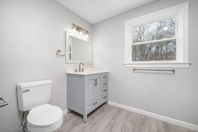 a bathroom with a toilet sink and mirror