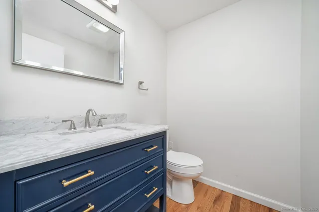 a bathroom with a granite countertop toilet and a sink