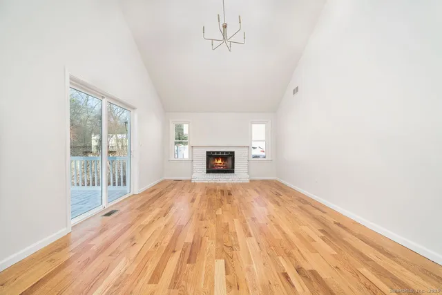a view of empty room with wooden floor and fireplace
