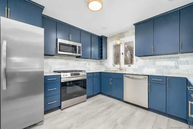a kitchen with granite countertop stainless steel appliances and cabinets