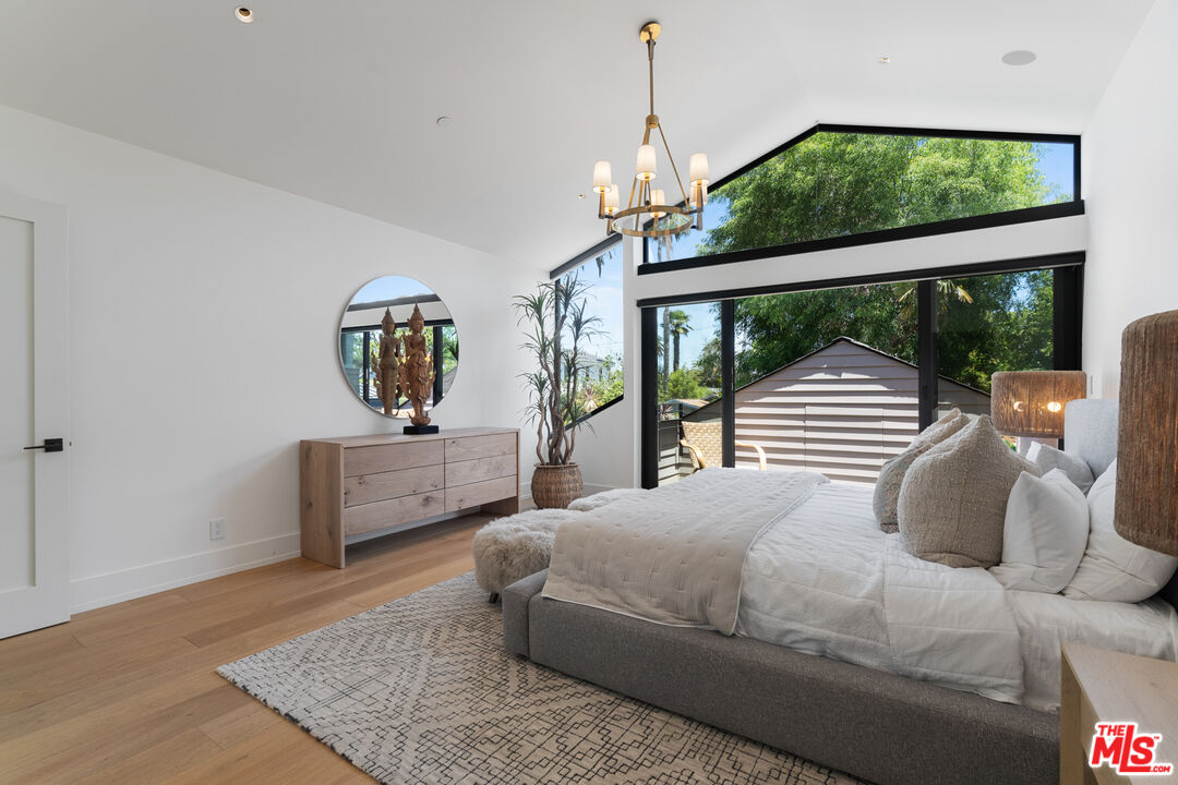 929 Marco Place Venice, CA 90291 - Photo 39 of 56 a bedroom with a bed a chandelier and large window