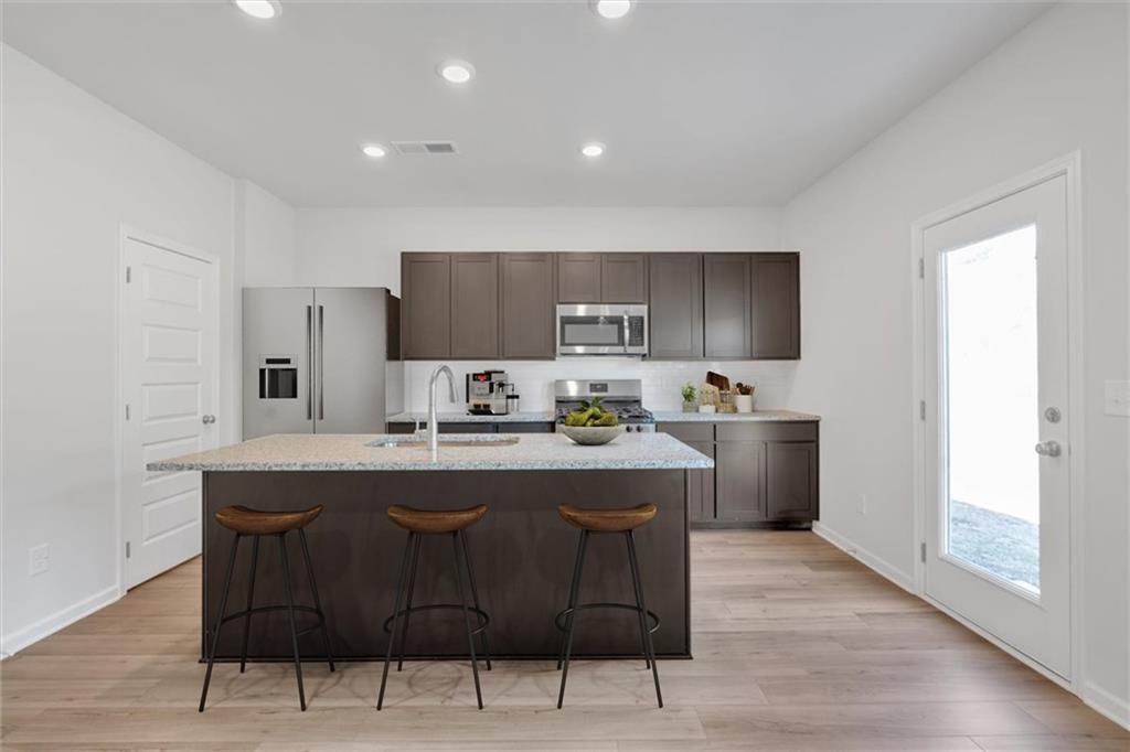 107 Lavender Circle Calhoun, GA 30701 - Photo 13 of 32 a kitchen with a sink a window and chairs