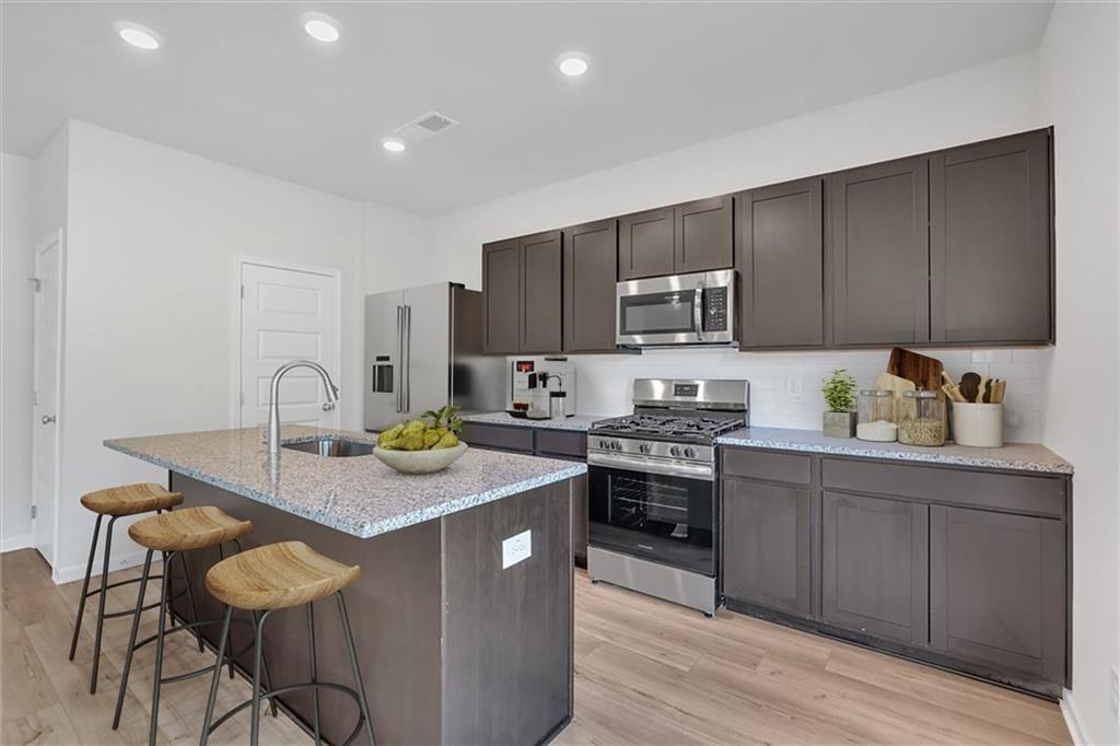 107 Lavender Circle Calhoun, GA 30701 - Photo 14 of 32 a kitchen with kitchen island granite countertop a sink and stove