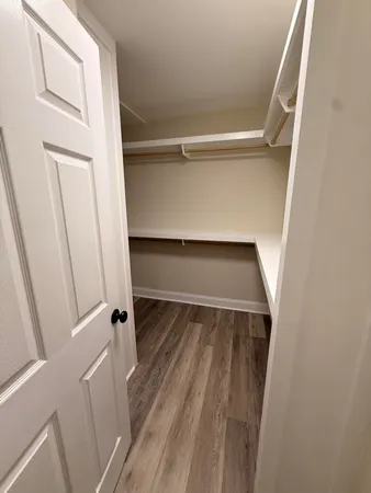 a view of walk in closet with empty racks