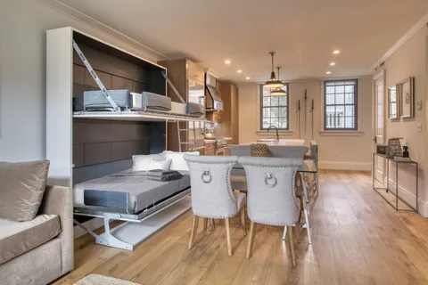 a kitchen with stainless steel appliances granite countertop a kitchen island hardwood floor sink stove dining table and chairs