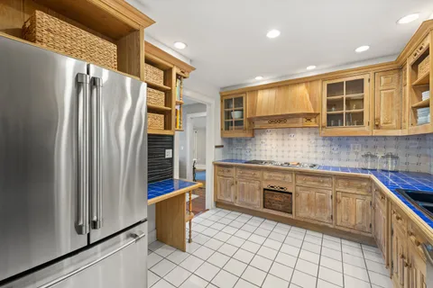 a kitchen with stainless steel appliances granite countertop a refrigerator and a stove top oven