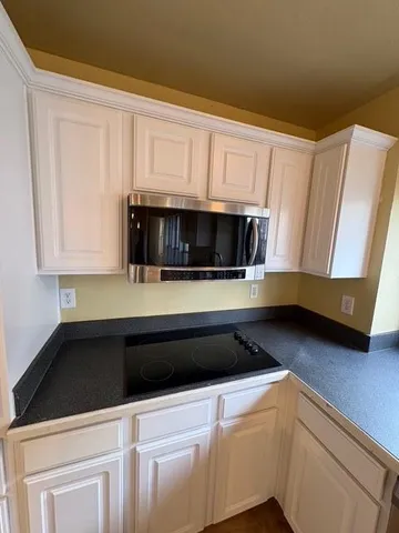 a kitchen with white cabinets and stainless steel appliances