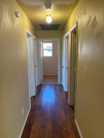 a view of a hallway with wooden floor