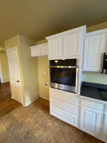 a kitchen with granite countertop white cabinets and white appliances
