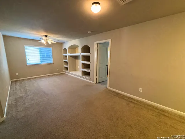 a view of an empty room with a cabinet and a window