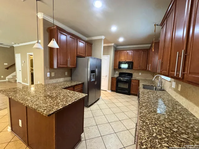 a kitchen with stainless steel appliances granite countertop a refrigerator a sink and a stove