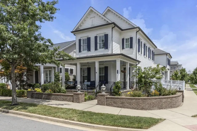 a front view of a house with porch and green space