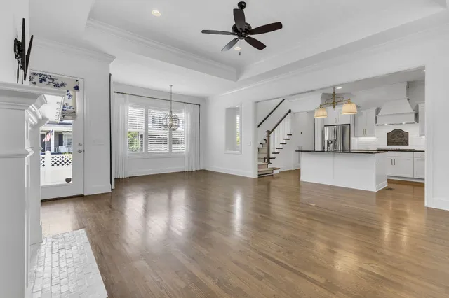 a view of an empty room with window and wooden floor