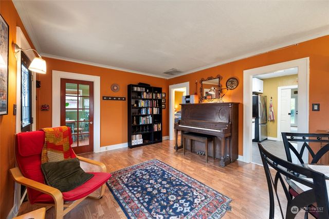 a living room with furniture a piano and a bookshelf