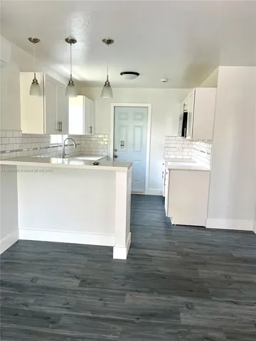 a kitchen with stainless steel appliances granite countertop a sink stove and wooden floor
