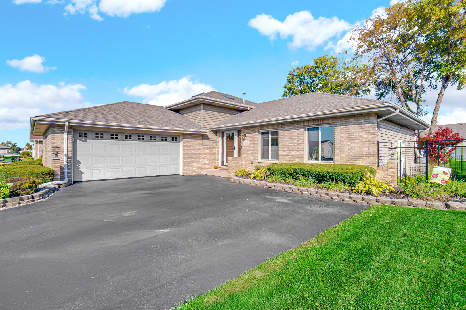 a front view of a house with a garden and plants