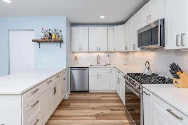 a kitchen with cabinets appliances a sink and a counter top space