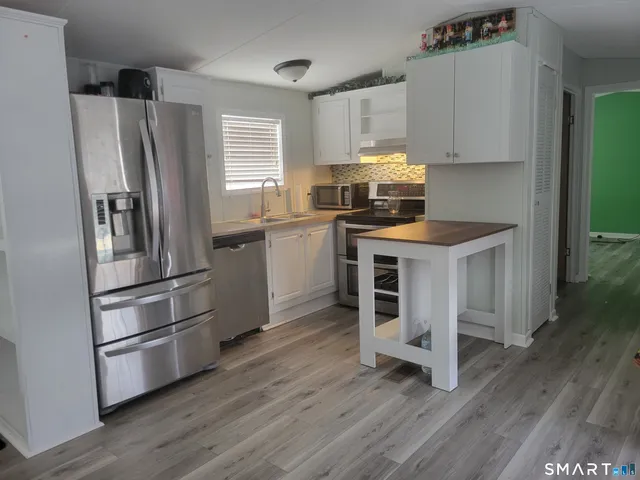 a kitchen with wooden floors and appliances