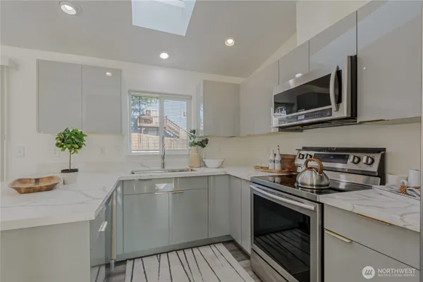 a kitchen with a sink a microwave and cabinets