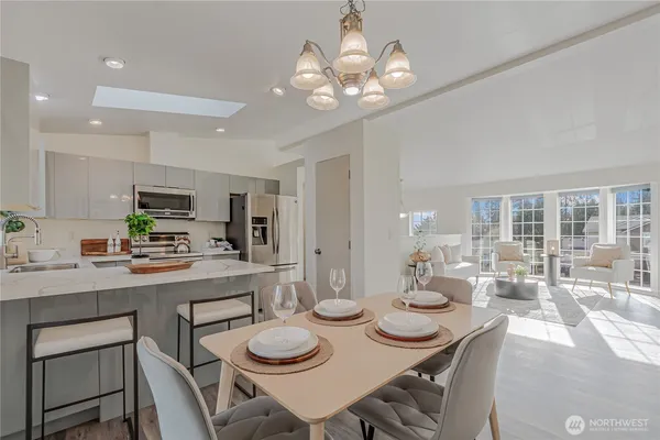 a dining room with kitchen island furniture a chandelier and kitchen view