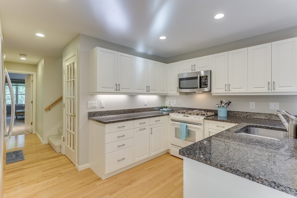 25 Rigsdale Way, Unit 25 Plymouth, MA 02360 - Photo 14 of 38 a kitchen with granite countertop a sink and cabinets