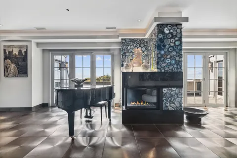 a living room with furniture a fireplace and a dining table with wooden floor