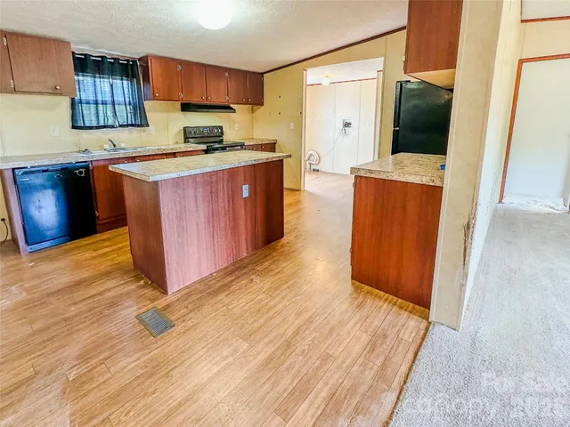 a kitchen with stainless steel appliances granite countertop a sink a stove top oven a refrigerator and cabinets