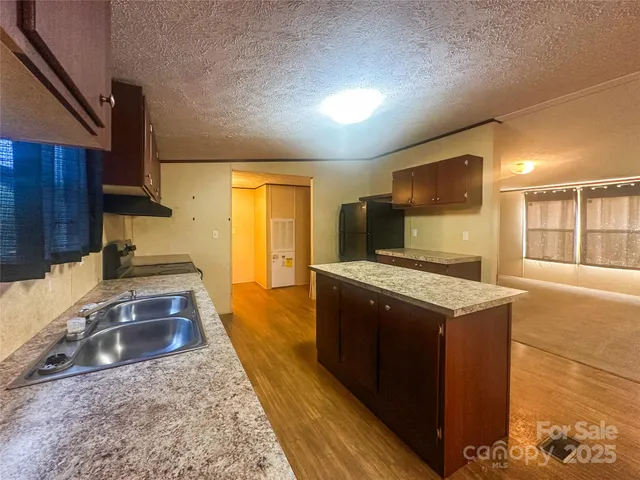 a view of a kitchen with a sink and a refrigerator