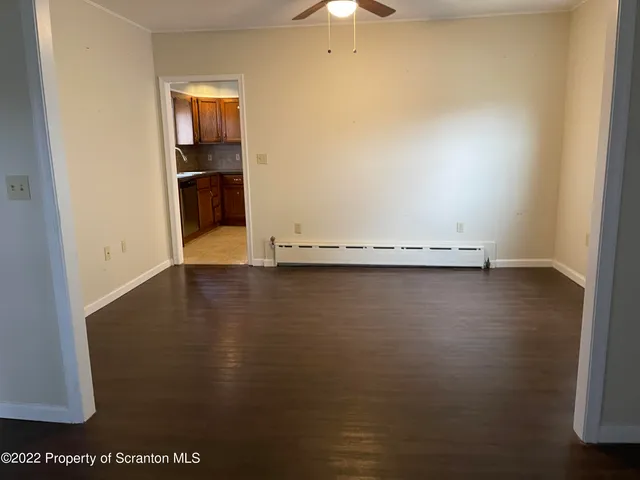 an empty room with a wooden floor and a window