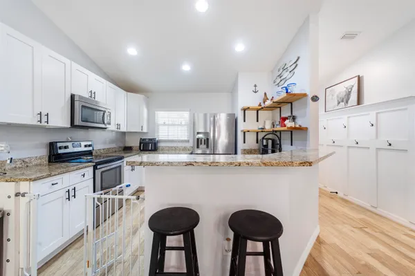 a kitchen with cabinets a sink and chairs in it