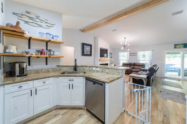 a kitchen with granite countertop a sink stove and cabinets