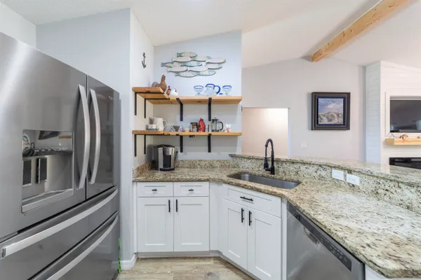 a kitchen with stainless steel appliances granite countertop a sink refrigerator and microwave