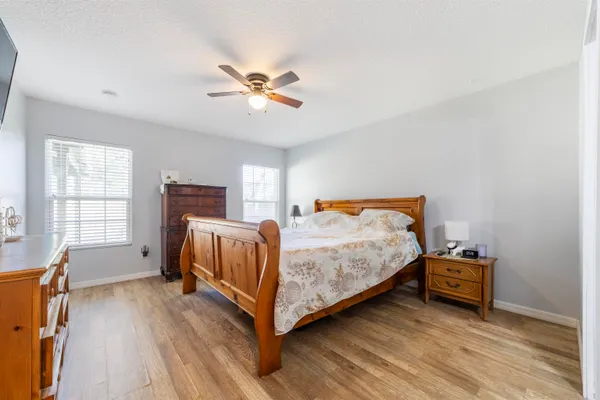 a bedroom with a bed and wooden floor