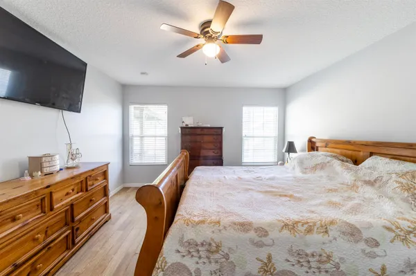 a bedroom with a bed and furniture with a flat tv screen