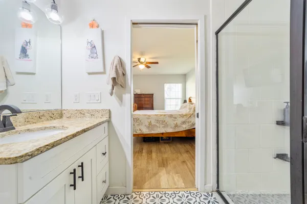 a en suite bathroom with a granite countertop sink and a mirror