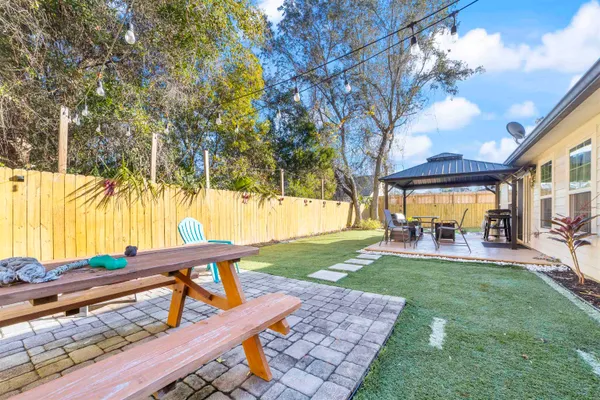 a view of a house with backyard and sitting area