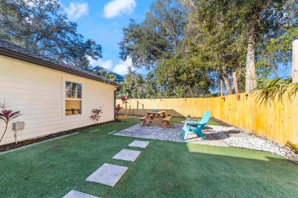 a backyard of a house with table and chairs