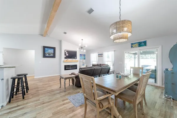 a view of a dining room with furniture a chandelier and wooden floor