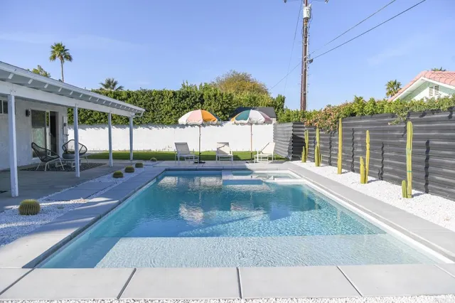 a view of a patio with couches table and chairs and potted plants