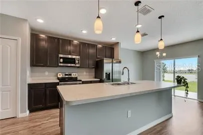 a kitchen with kitchen island a sink stainless steel appliances and cabinets
