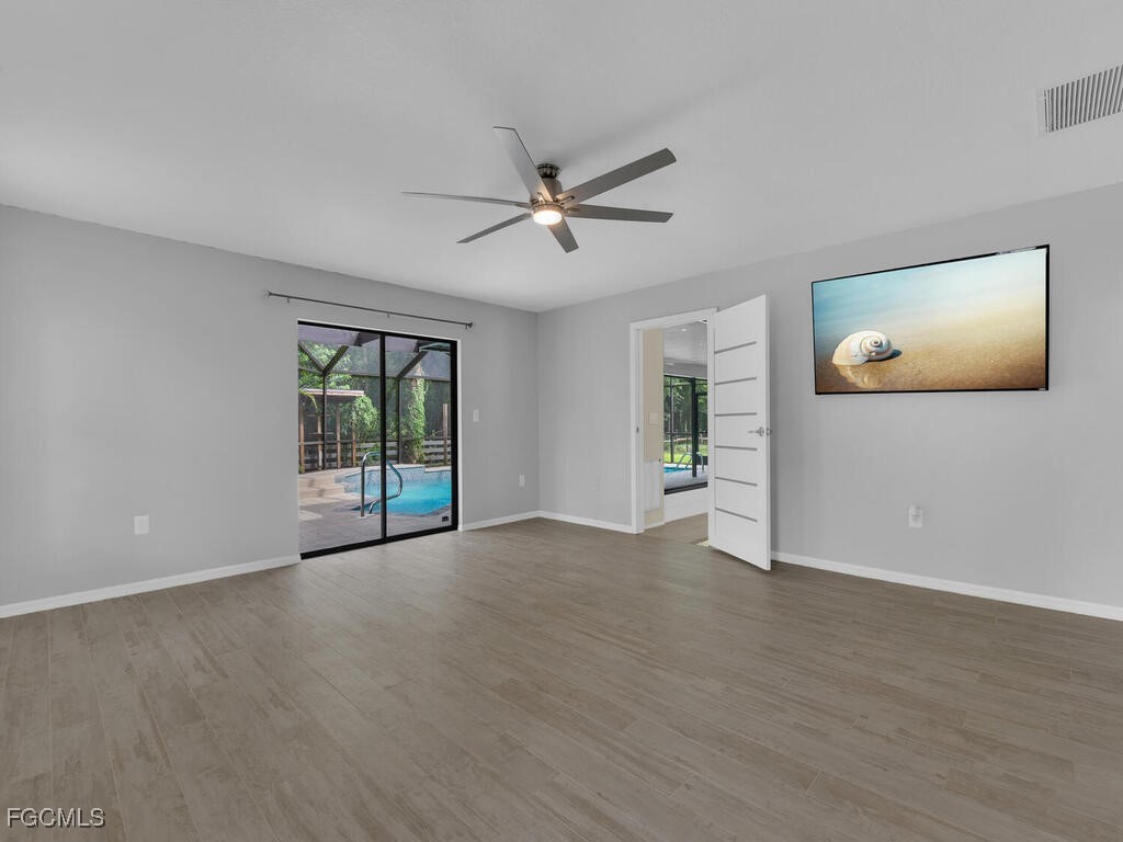 11981 Plantation Road Fort Myers, FL 33966 - Photo 16 of 48 a view of an empty room with a window and a kitchen