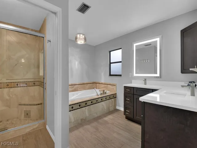a bathroom with a tub sink and mirror